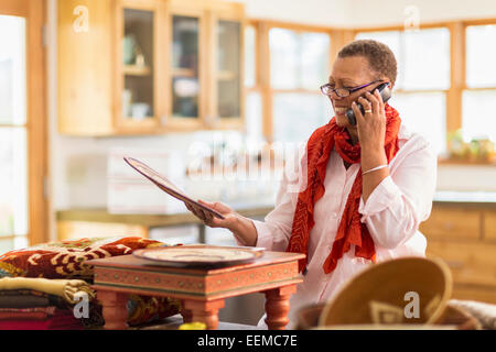 Plus mixed race Woman talking on telephone in home office Banque D'Images