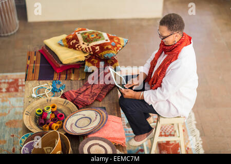 Plus mixed race woman using digital tablet in office Banque D'Images