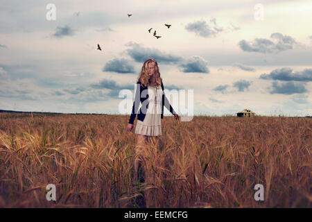 Caucasian teenage Girl standing in field of tall grass Banque D'Images