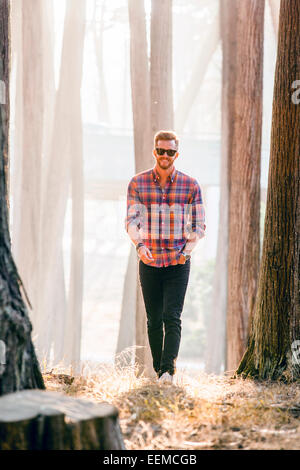 Caucasian man explorer la forêt ensoleillée Banque D'Images