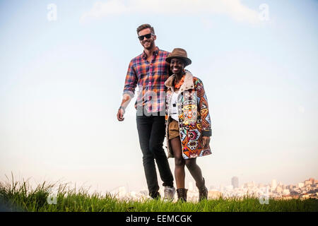 Couple walking together in grassy field Banque D'Images