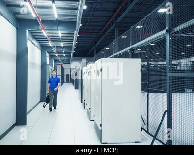 Caucasian businessman walking in server room Banque D'Images