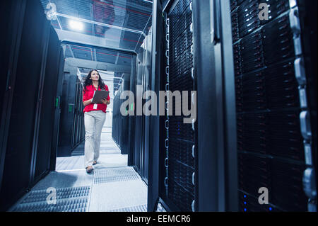 Caucasian businesswoman reading clipboard in server room Banque D'Images