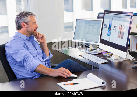 Caucasian businessman working at computer in office Banque D'Images