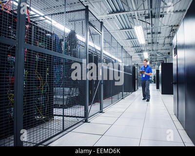 Technicien caucasienne using digital tablet in server room Banque D'Images