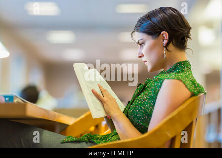 Mixed Race student studying in library Banque D'Images