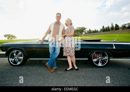 Couple smiling près de convertible classique Banque D'Images