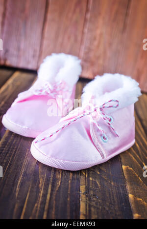 Chaussures bébé sur la table en bois, chaussures rose Banque D'Images