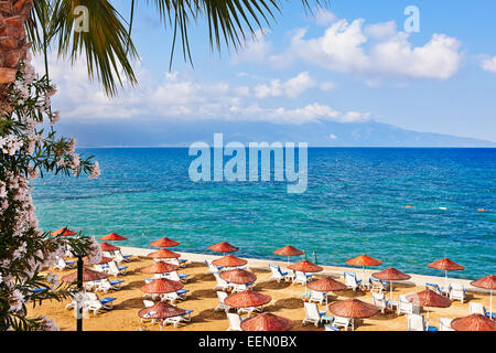 Chaises longues et parasols sur une plage privée. Kusadasi, province d'Aydin, Turquie. Banque D'Images