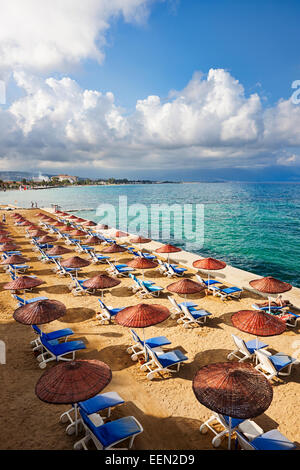 Des parasols et des chaises longues sur la plage de Kusadasi, Aydin, Province de la Turquie. Banque D'Images