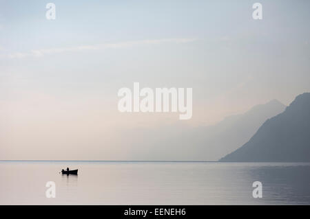 Le dirigeant d'une voile à l'horizon de la grande du lac de garde dans le nord de l'Italie avec un ciel bleu clair matin. Banque D'Images