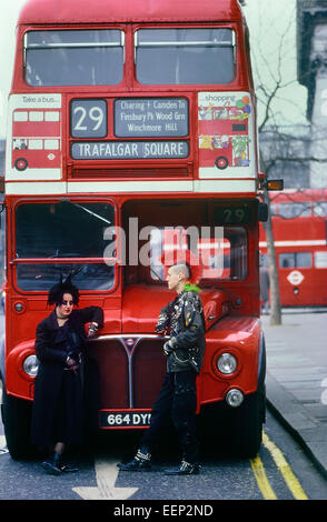 Punk couple standing in front of a London Double-Decker bus Routemaster. Banque D'Images