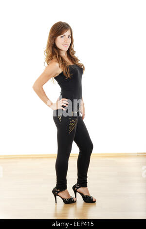 Jeune femme en noir pantalon serré et des talons hauts qui pose en pleine longueur Banque D'Images