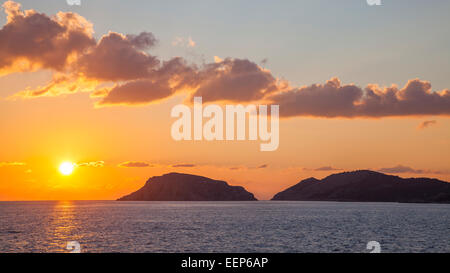 Coucher du soleil au large de la côte de l'île grecque de Symi dans le Dodécanèse Grèce Europe Banque D'Images