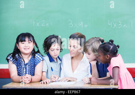 Avec l'enseignant en classe multiethnique expliquant leçon de mathématiques. Banque D'Images