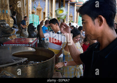 Priez et offrandes, bot, Bouddha, prières, Personnes, Temple, Wat Phra Kaeo, Grand Palace, Bangkok, Thailande, Asie. Les gens prient thaï Banque D'Images