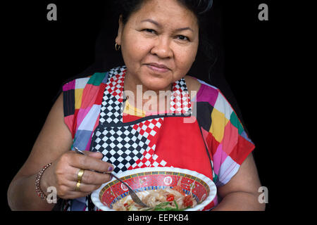 Une femme de manger une salade de papaye verte typique dans les rues de Bangkok. Cette salade de papaye verte, également connu sous le nom de 'Som', tam est populaire Banque D'Images