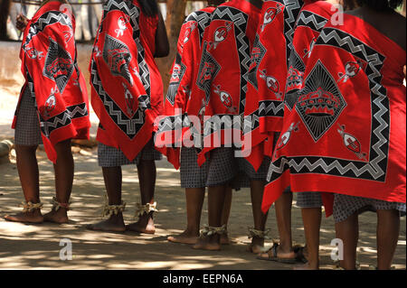 Robes rouges colorés traditionnels des femmes Swazi dancers dancing in a row, effectuant une danse à Matsamo village culture, au Swaziland Banque D'Images