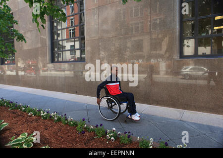 L'homme en fauteuil roulant avec la méningite à l'aide d'un trottoir de la ville Banque D'Images