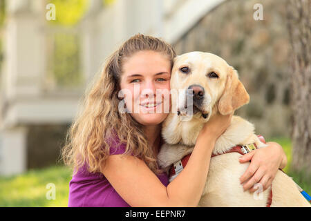 Femme avec déficience visuelle serrant son chien aidant Banque D'Images