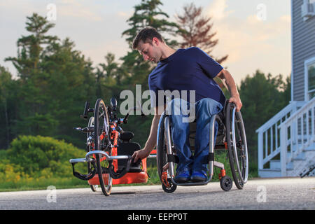 L'homme avec de la moelle épinière dans son fauteuil roulant avec son cycle de la main d'adaptation personnalisée Banque D'Images