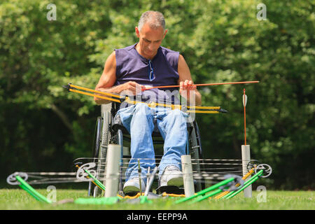 L'homme avec de la moelle épinière en fauteuil roulant pour la pratique du tir à l'établissement Banque D'Images