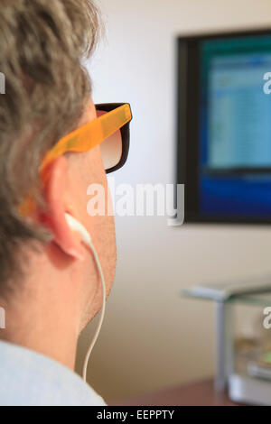 L'homme avec la cécité congénitale en utilisant la technologie d'assistance à son ordinateur pour écouter Banque D'Images