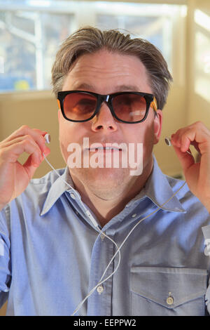 L'homme avec la cécité congénitale en utilisant la technologie d'aide à l'écoute Banque D'Images