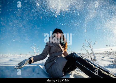 Girl se situe sous la neige qui tombe Banque D'Images