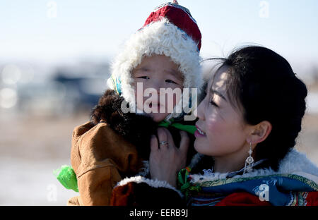 Bannière Ujimqin l'Est de la Chine, région autonome de Mongolie intérieure. 21 Jan, 2015. Une femme prend son fils à un hiver au Nadam Bannière Ujimqin, Chine du nord, région autonome de Mongolie intérieure, le 21 janvier 2015. Nadam de masse est un festival mongol traditionnel où les gens célébrer les récoltes et prier pour la bonne chance. © Ren Junchuan/Xinhua/Alamy Live News Banque D'Images