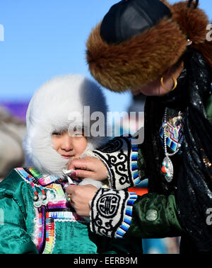 Bannière Ujimqin l'Est de la Chine, région autonome de Mongolie intérieure. 21 Jan, 2015. Femme porte un chapeau pour son enfant pendant un hiver au Nadam Bannière Ujimqin, Chine du nord, région autonome de Mongolie intérieure, le 21 janvier 2015. Nadam de masse est un festival mongol traditionnel où les gens célébrer les récoltes et prier pour la bonne chance. © Ren Junchuan/Xinhua/Alamy Live News Banque D'Images