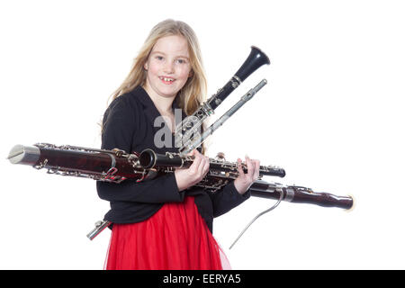 Jeune fille blonde est titulaire d'instruments à vent en studio against white background Banque D'Images