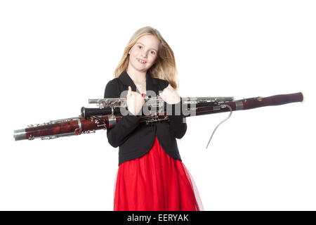 Jeune fille blonde est titulaire d'instruments à vent en studio against white background Banque D'Images