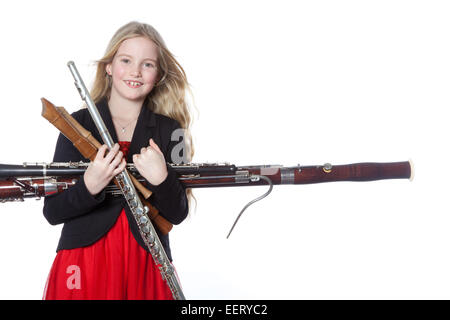 Jeune fille blonde est titulaire d'instruments à vent en studio against white background Banque D'Images