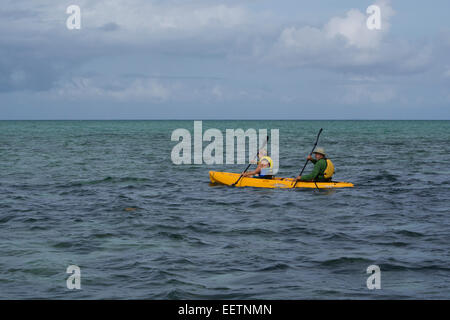 Leleuvia Island, Fidji. Couple en jaune kayak autour de l'île fidjienne populaires. Banque D'Images