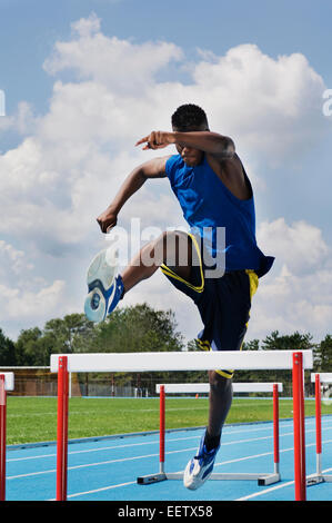 Man jumping obstacles sur une piste Banque D'Images