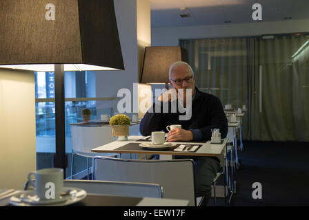 Mâle mature businessman au petit-déjeuner seul dans un hôtel Banque D'Images