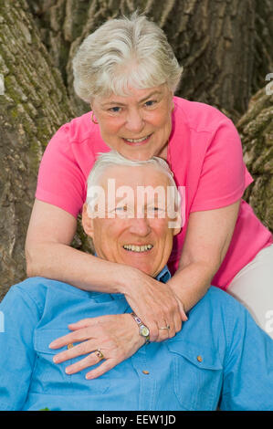 Senior couple posing contre un arbre Banque D'Images