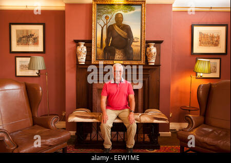 Mâle mature assis dans une salle de trophées avec une peinture chieftan Banque D'Images