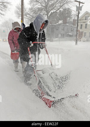 New Haven-- 14 ans Kyle Petrone souffle la neige sur le trottoir le long de l'Avenue de Whitney, suivi par sa mère, Christina Wilkus comme ils essayaient de rester au matin de neige. 21/01/12 Banque D'Images