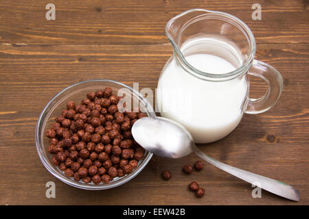 Bol à céréales chocolat et pot de lait sur table en bois vu de dessus Banque D'Images