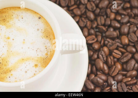 Espresso en grains et une tasse de cappuccino Banque D'Images