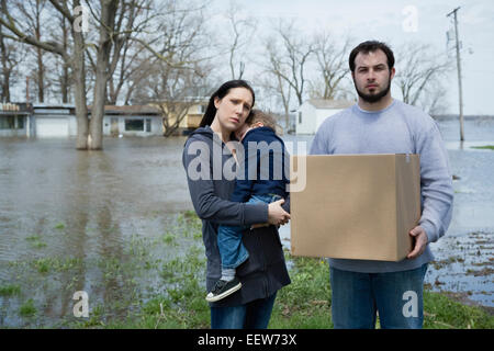 Les parents avec fils debout dans la ville inondée Banque D'Images