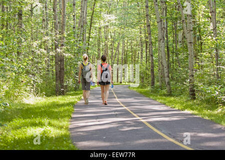 Deux amies marchant le long d'une piste cyclable dans la forêt Banque D'Images