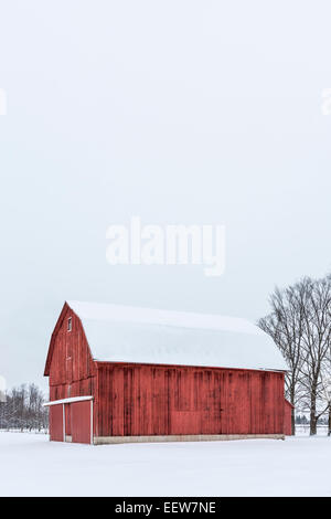 Grange rouge classique sur un jour de neige glacée dans Mecosta comté près de Grand Rapids et Stanwood, Michigan, USA Banque D'Images