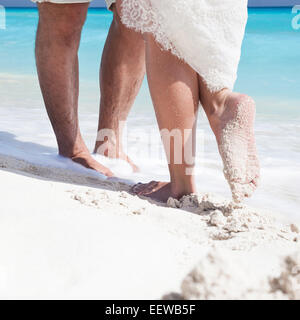 Gros plan sur les pieds mâles et femelles, les baisers de sable blanc Banque D'Images