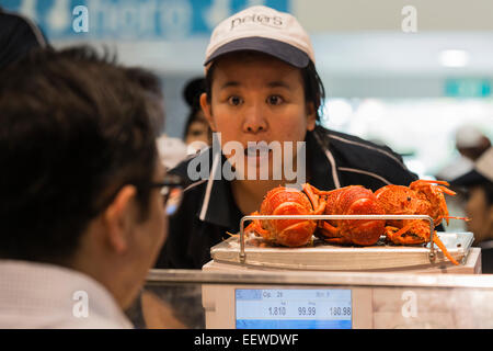 Poissonnier poissons coquille femme pesant à Peter's Fish Market, une boutique au marché aux poissons de Sydney, la veille de Noël 2014. L'Australie Banque D'Images