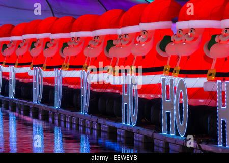 Gonflé lumineux Père Noël avec les mots "ho, ho, ho' sur un ponton flottant dans la nuit, Noël 2014, Darling Harbour. Banque D'Images