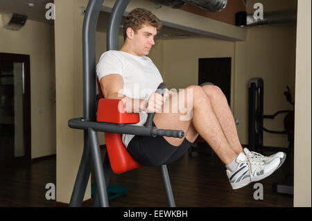 Jeune homme faisant le lats workout Banque D'Images