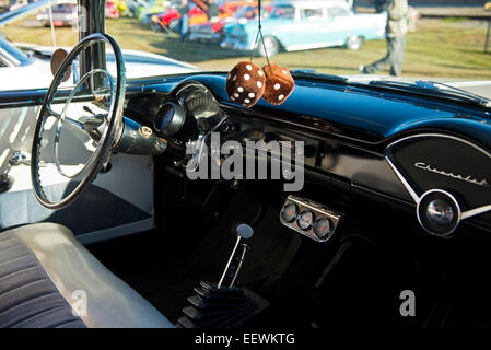 1960 Chevrolet Classic car dashboard détail avec volant et fuzzy dice hanging from mirror Banque D'Images